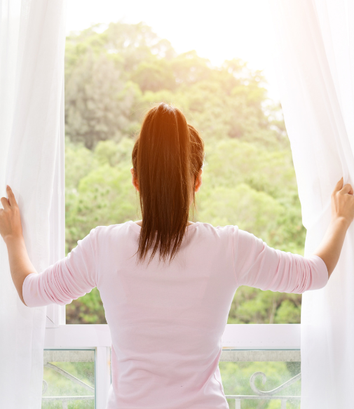 Woman looking out a windows - TALIANA care and maintenance